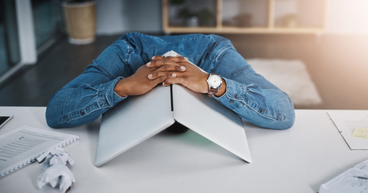 Person with head down on closed laptop — when your mind won't stop racing at night